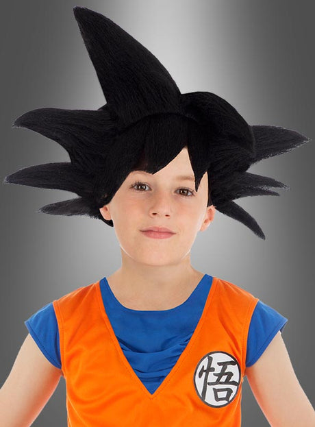 Ein Kind, das die Perücke „Goku Kinder schwarz Dragonball“ – eine schwarze Perücke mit Stacheln – und ein orange-blaues Son-Goku-Kinderkostüm mit einem japanischen Kanji-Zeichen trug, posierte vor einem grauen Hintergrund mit Farbverlauf.