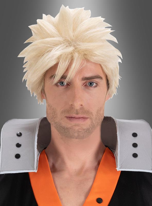 Ein Mann, der eine Katsuki-Bakugo-Perücke aus „My Hero Academia“ für Erwachsene mit stacheligen blonden Haaren und ein schwarz-orangefarbenes Bakugo-Kostüm mit großen grauen Schulterpolstern trägt, blickt vor einem grauen Hintergrund nach vorne.