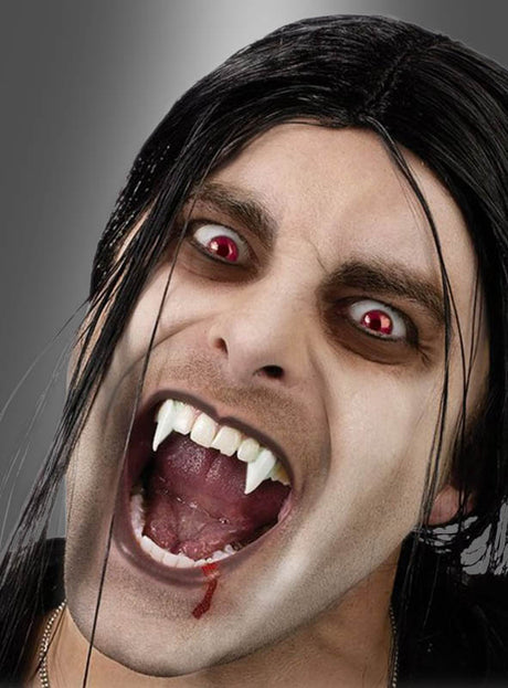 Eine Person mit blasser Haut, roten Augen und langen dunklen Haaren entblößt ihre ausfahrbaren Vampirzähne – den Mund weit geöffnet, mit einem Blutstropfen auf der Unterlippe –, während sie vor einem grauen Hintergrund ein auffälliges Halloween-Kostüm präsentiert.