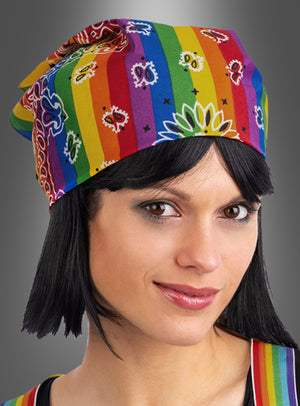 Eine Person mit glattem schwarzem Haar trägt ein farbenfrohes Hippie-Kopftuch-Stirnband mit Regenbogen-Paisley-Mustern, das wie ein Bandana gestylt ist und sich vor einem grauen Hintergrund mit Farbverlauf abhebt.
