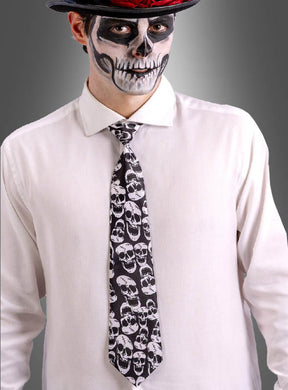 Eine Person, die ein weißes Hemd, eine Totenkopf-Krawatte für Halloween und einen Hut trägt und deren Gesicht mit einem schwarz-weißen Totenkopf-Motiv bemalt ist.