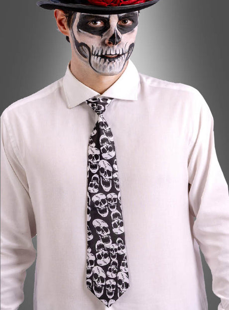 Eine Person, die ein weißes Hemd, eine Totenkopf-Krawatte für Halloween und einen Hut trägt und deren Gesicht mit einem schwarz-weißen Totenkopf-Motiv bemalt ist.