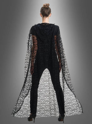 Eine Person steht mit dem Rücken zur Kamera und trägt den „Umhang aus Spitze 140 cm mit Totenköpfen“ – einen eleganten, transparenten schwarzen Umhang, der mit Totenkopfmotiven verziert ist – über einem schwarzen Outfit und High Heels, vor einem grauen Hintergrund mit Farbverlauf.