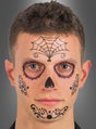Ein Mann mit kurzen braunen Haaren trägt schwarze und violette „Sugar Skull“-Gesichtsbemalung – mit einem Spinnennetz-Motiv auf der Stirn, verzierten Augenringen, einer schwarzen Nase sowie kunstvollen Details auf den Wangen und am Mund –, die dem „Tattoo Day of the Dead“-Gesichtstattoo ähnelt.