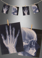 Röntgenbilder einer Hand und eines Schädels sind an einer Schnur befestigt und werden ausgestellt, wodurch eine auffällige „Röntgenbilder-Kette 160 cm ohne Licht“ mit einem graustufigen Hintergrund entsteht – perfekt für Ihre Halloween-Partydekoration oder Skelett-Dekoration.