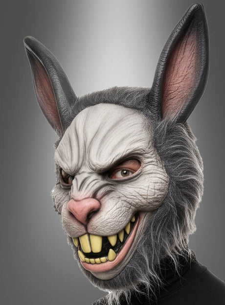 Eine Person trägt die „Kaninchen-Maske mit Fell“, eine detailreiche und realistische Maske mit scharfen Zähnen und übertriebenen Gesichtszügen, vor einem neutralen Hintergrund; diese gruselige Hasenmaske ist die perfekte Halloween-Maske für alle, die einen unvergesslichen Look suchen.