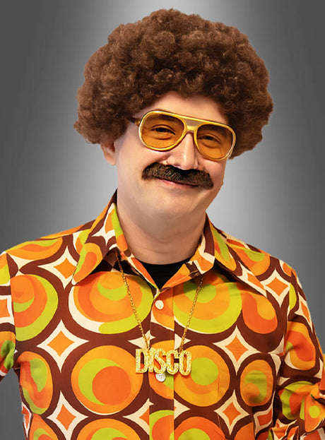 Ein Mann, der das „Disco-Set für Herren mit Bart und Perücke“ trägt – bestehend aus einem Hemd mit Retro-Muster, einer großen Sonnenbrille, einer Afro-Perücke, einem falschen Schnurrbart und einer goldenen DISCO-Halskette –, posiert vor einem grauen Hintergrund und ist damit bereit für jede 70er-Jahre-Kostümparty oder jede Disco-Veranstaltung.