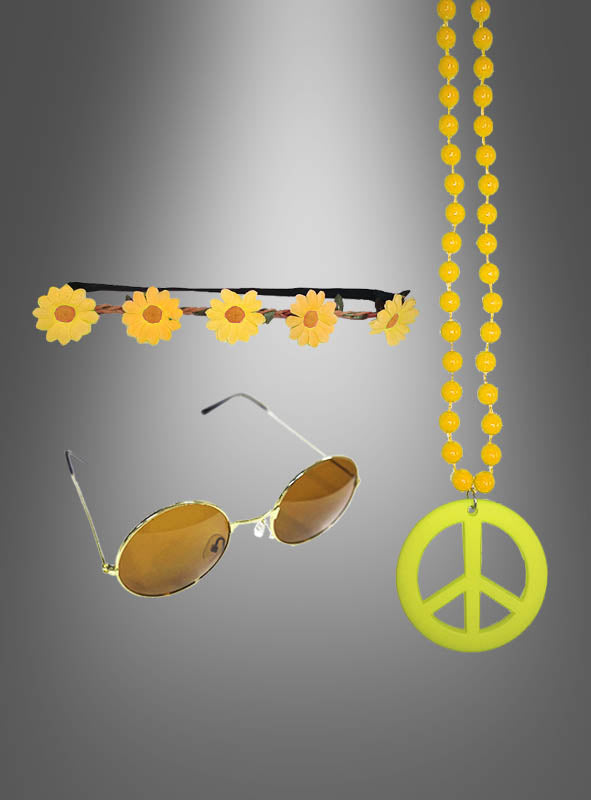 Das „Sonnenblumen Hippie Set mit Brille gelb“ – bestehend aus einem Gänseblümchen-Stirnband, einer runden, gelb getönten Sonnenbrille und einer gelben Perlenkette mit einem großen Peace-Zeichen-Anhänger – sorgt vor einem grauen Farbverlaufshintergrund für das ultimative Flower-Power-Feeling – perfekt für jeden Retro-Look.