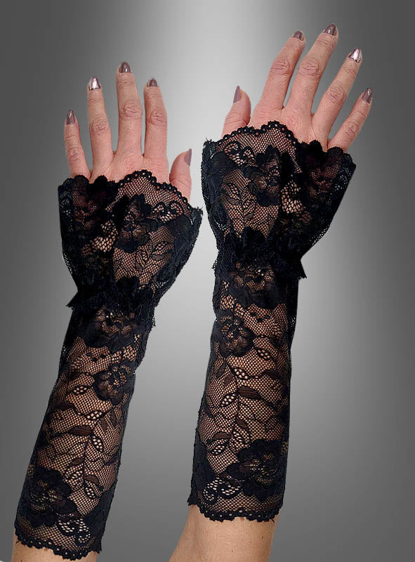 Vor einem grauen Hintergrund mit Farbverlauf sind zwei Hände zu sehen, an denen lange, schwarze, fingerlose „Romantische Spitzen Armstulpen“ mit Blumenmuster getragen werden – perfekt für den Gothic-Stil.