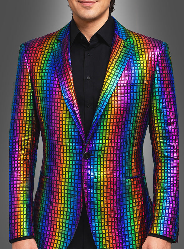 Ein Mann ist von den Schultern bis zur Mitte der Oberschenkel zu sehen. Er trägt das „Regenbogen Sakko für Herren“ – ein farbenfrohes, glänzendes Sakko – über einem schwarzen Hemd, vor einem einfarbigen Hintergrund mit Farbverlauf.