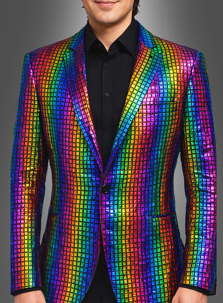 Ein Mann ist von den Schultern bis zur Mitte der Oberschenkel zu sehen. Er trägt das „Regenbogen Sakko für Herren“ – ein farbenfrohes, glänzendes Sakko – über einem schwarzen Hemd, vor einem einfarbigen Hintergrund mit Farbverlauf.