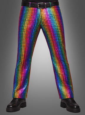 Eine Person, die schwarze Schuhe, einen schwarzen Gürtel und die „Regenbogen Hose für Herren“ trägt – eine glänzende Disco-Hose mit Pailletten und einem bunten Regenbogen-Karomuster –, steht vor einem grauen Hintergrund.