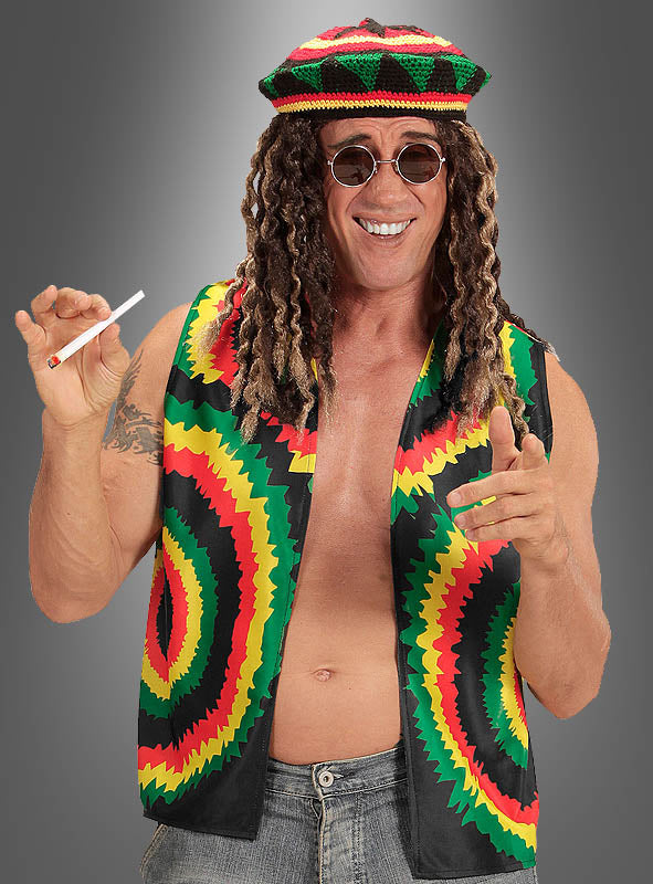 Ein Mann, der eine „Reggae Karibik Weste Batik“ in leuchtenden Rastafari-Farben, eine Sonnenbrille und eine Perücke mit Dreadlocks trägt, eine Zigarette in der Hand hält, lächelt und vor einem schlichten grauen Hintergrund mit dem Finger zeigt – perfekt für jede jamaikanische Veranstaltung.
