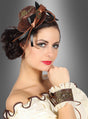 Eine Frau präsentiert das Steampunk-Minihut-und-Manschetten-Set – bestehend aus einem braunen Mini-Zylinder, der mit Zahnrädern und Bändern verziert ist, kombiniert mit einem schulterfreien Kleid und einer mit Spitze besetzten Ledermanschette mit Zahnrad-Akzenten – und posiert vor einem grauen Hintergrund mit Farbverlauf, wodurch ein atemberaubendes Steampunk-Kostüm für Damen entsteht.