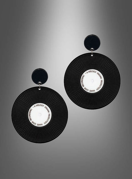 Ein Paar „80er“-Ohrringe im Schallplatten-Design in Schwarz-Weiß: schwarze, runde Ohrringe mit weißen Mittelstücken, die an Schallplatten erinnern, präsentiert vor einem grauen Hintergrund mit Farbverlauf.