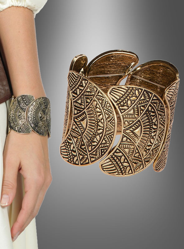 Das „Massives Boho Armband Hippie Style“ ist ein breites, goldfarbenes Armreif-Armband mit aufwendigen geometrischen Mustern. Ob am Handgelenk getragen oder separat vor einem grauen Farbverlaufshintergrund präsentiert – dieses auffällige Accessoire verkörpert den Geist des Hippie-Stils und sorgt für einen unvergesslichen, Blickfang.