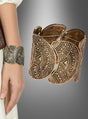 Das „Massives Boho Armband Hippie Style“ ist ein breites, goldfarbenes Armreif-Armband mit aufwendigen geometrischen Mustern. Ob am Handgelenk getragen oder separat vor einem grauen Farbverlaufshintergrund präsentiert – dieses auffällige Accessoire verkörpert den Geist des Hippie-Stils und sorgt für einen unvergesslichen, Blickfang.