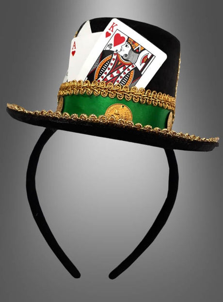 Wir präsentieren den „Casino Mini Hut am Haarreif“: ein schickes Stirnband, verziert mit einem schwarzen Zylinder, der mit goldenen Borten, einem grünen Band und zwei Spielkarten – dem Herz-Ass und dem Herz-König – verziert ist, die geschickt in das Band eingearbeitet sind. Dieses elegante Damen-Accessoire ist der perfekte letzte Schliff für Ihr glamouröses Las-Vegas-Kostüm oder um Ihr nächstes „Casino Mini Hut“-Outfit aufzuwerten.