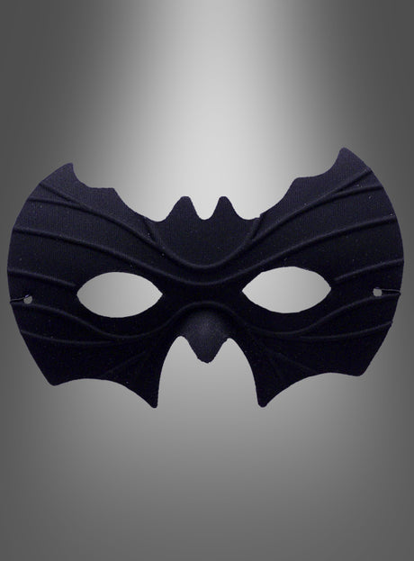 Eine schwarze Fledermaus-Halbmaske mit spitzen, fledermausartigen Kanten und eleganten, geschwungenen Linien, dargestellt vor einem grauen Hintergrund mit Farbverlauf.