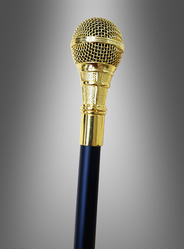Ein massiver Mikrofon-Spieß-Gehstock (94 cm) in Gold mit schwarzem Griff wird vor einem grauen Hintergrund mit Farbverlauf präsentiert und ist damit das perfekte Accessoire für Ihr Sänger-Kostüm oder Rapper-Kostüm.