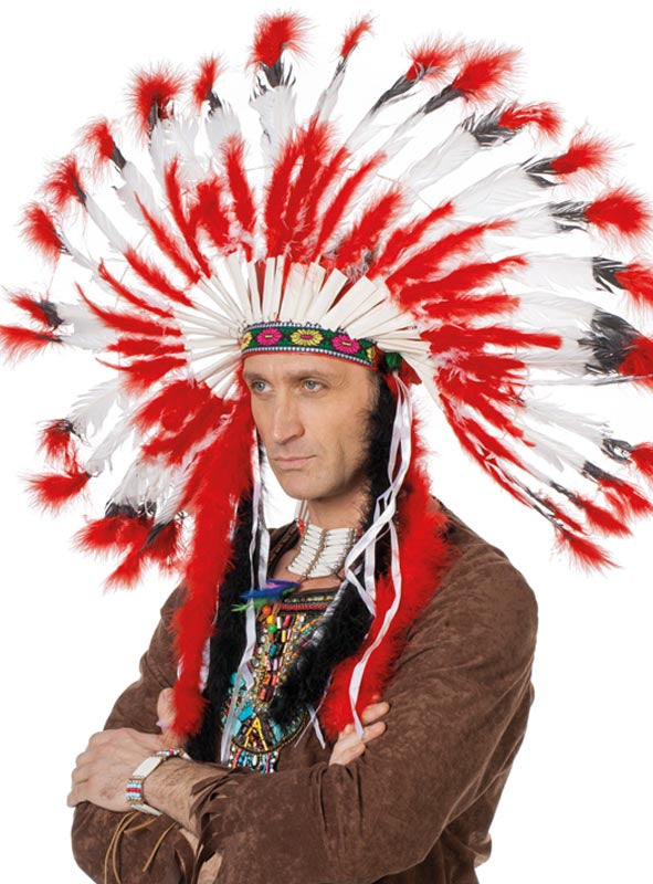 Eine Person, die den „Indianer Häuptling Kopfschmuck Deluxe rot-weiß“ – einen großen Kopfschmuck mit roten und weißen Federn – sowie ein braunes Häuptling-Kostüm trägt, steht mit verschränkten Armen vor einem einfarbigen Hintergrund.