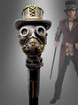 Im Hintergrund hält eine Person in einem Steampunk-Kostüm den „Deluxe Gehstock Steampunk“ – einen im Steampunk-Stil gestalteten Spazierstock mit einem Griff in Form einer Gasmaske, die einen Zylinder trägt – als auffälliges Kostümzubehör in der Hand.