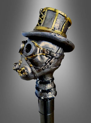 Ein metallener Kopf im Steampunk-Stil, geschmückt mit einer Schutzbrille, einer Gasmaske und einem Zylinder, ist auf dem „Deluxe Gehstock Steampunk“-Stab befestigt und vor einem grau verlaufenden Hintergrund platziert – damit ist er das ideale Kostümzubehör für jedes Steampunk-Kostüm.