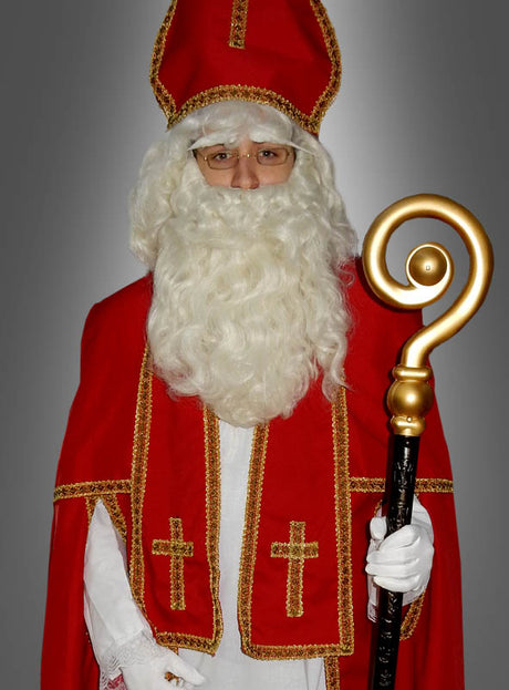 Eine Person in einem eleganten Nikolauskostüm, bestehend aus einem rot-weißen Gewand mit goldenen Verzierungen, einem hohen Hut und weißen Handschuhen, die einen goldenen Stab mit spiralförmiger Spitze in der Hand hält. Abgerundet wird der Look durch die Deluxe-Weihnachtsmann-Perücke und den Bart, die für ein authentisches Nikolaus-Erscheinungsbild sorgen.