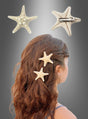 Eine Frau mit welligem braunem Haar schmückt ihre Frisur mit der „1 St. Haarspange Seestern für Nixen“, einer Haarspange in Form eines Seesterns, die ihrem Look einen verspielten, maritimen Touch verleiht. Über ihr zeigen Nahaufnahmen sowohl die Vorder- als auch die Rückseite der Haarspange sowie deren Metallverschluss – damit ist sie das ideale Accessoire, um jedes Haarschmuck-Ensemble im Meerjungfrauen-Stil oder jedes Meerjungfrauen-Kostüm zu vervollständigen.