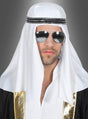 Ein Mann, der die Scheich-Kopfbedeckung im Orient mit einem weißen Schleier, einem schwarz-goldenen Gewand und einer Pilotenbrille trägt, steht vor einem grauen Hintergrund und vermittelt die Eleganz eines Orient-Kostüms.