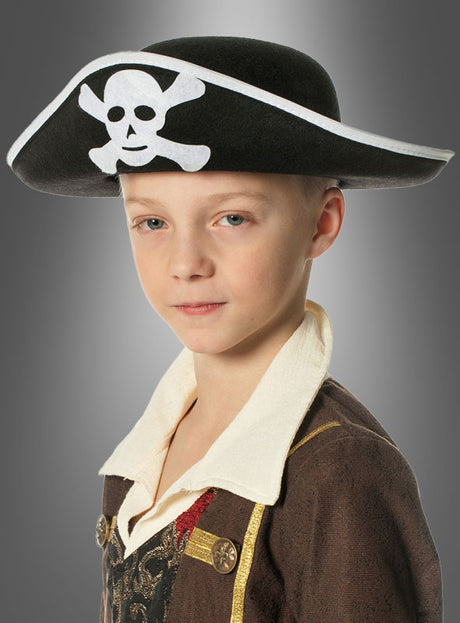 Ein kleines Kind, das einen schwarzen Piratenhut mit Totenkopf trägt und dazu ein bezauberndes braunes Piratenkostüm mit weißem Kragen, posiert für ein Porträt vor grauem Hintergrund.