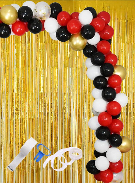 Ballongirlanden-Partyset, 113-teilig, schwarz, rot, gold, bestehend aus roten, schwarzen, weißen und goldenen Luftballons vor einem goldenen Fransenhintergrund. Das Set inklusive Ballon-Dekorationsstreifen und Band ist unten links im Bild zu sehen.