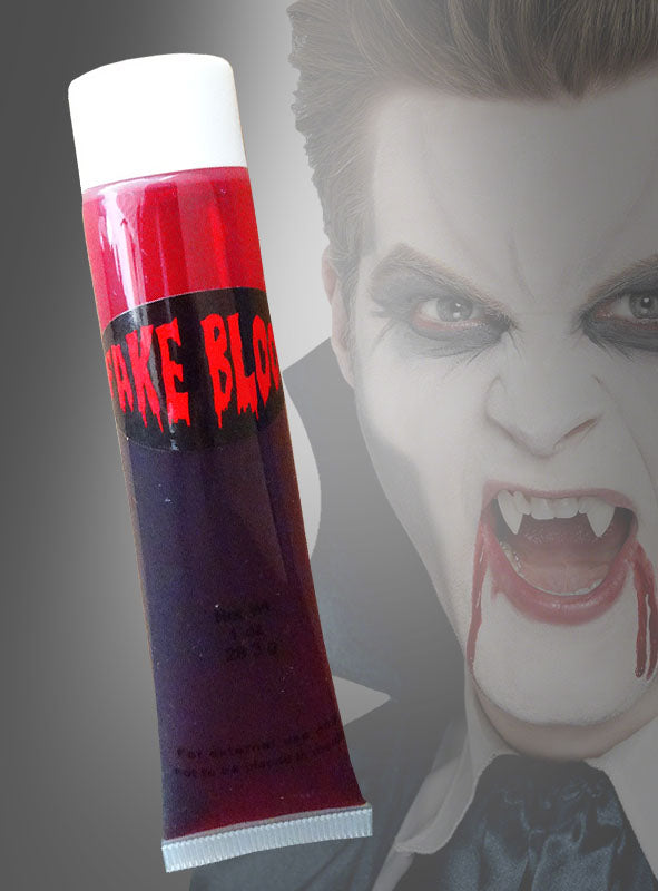 Vor einer Person in einem Vampirkostüm, der Reißzähne trägt und aus deren Mund Kunstblut tropft, ist eine „Fake Blut Tube 30 ml für Vampire“ zu sehen.