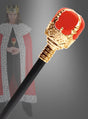 Eine Nahaufnahme des 47 cm großen „Zepter für Königskostüme“, einem unverzichtbaren Karnevalskostüm-Accessoire in Rot und Gold, mit einer unscharfen Gestalt im Hintergrund, die als König mit Krone und Umhang verkleidet ist.