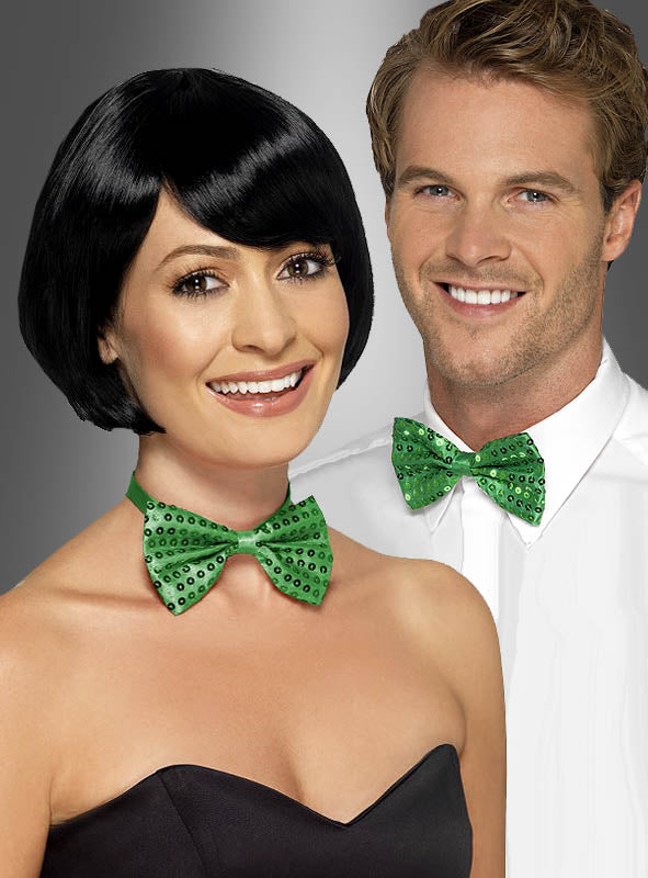 Eine Frau in einem trägerlosen schwarzen Oberteil und ein Mann in einem weißen Hemd tragen beide die „Grüne Fliege mit Pailletten“ als Accessoire zum St. Patrick’s Day und lächeln in die Kamera.