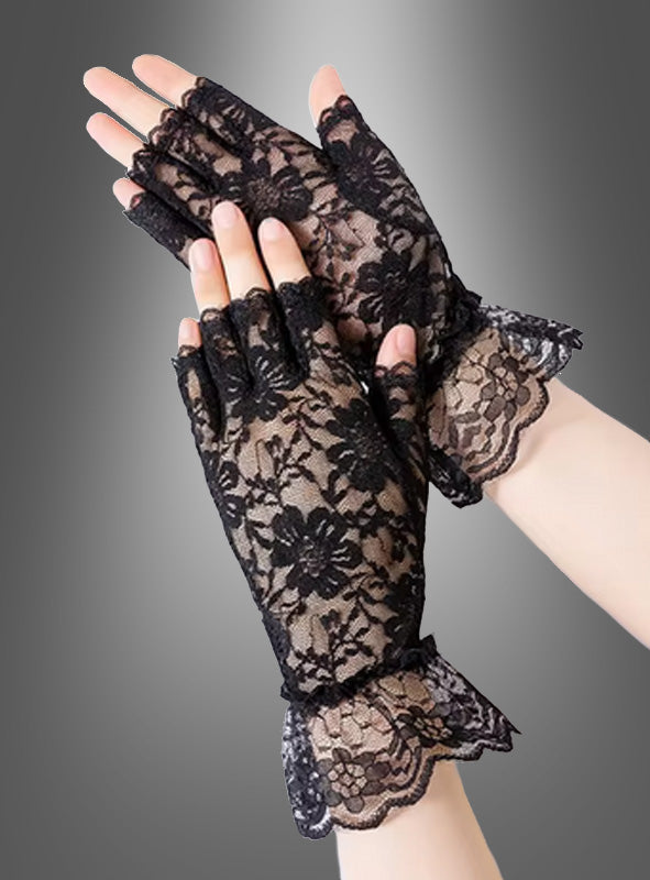 Ein Paar Hände, die fingerlose Handschuhe mit Spitzen und Blumenmustern sowie gerüschten Bündchen tragen, die an Kostüme aus den 80er Jahren erinnern, vor einem grauen Hintergrund mit Farbverlauf.