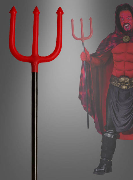 Im Vordergrund ist eine „Teufelsgabel“ Forke (105 cm) zu sehen, während im Hintergrund eine Person in einem Teufelskostüm eine ähnliche Heugabel in der Hand hält.