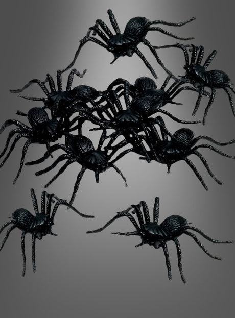 Ein Set aus 12 Plastikspinnen (5 cm) ist vor einem grauen Hintergrund mit Farbverlauf angeordnet und verleiht Ihrer Halloween-Dekoration den perfekten gruseligen Touch.