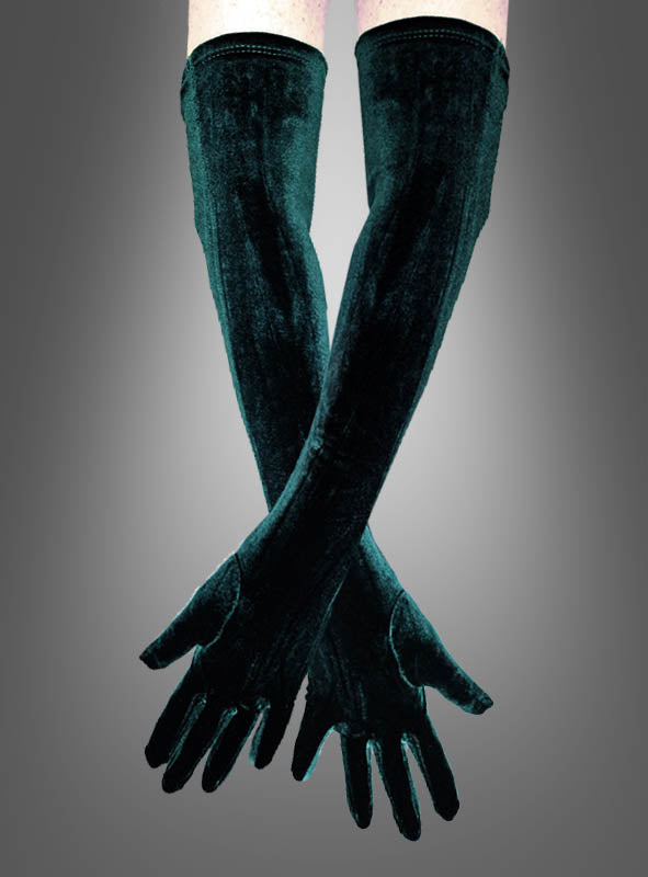 Ein Paar verschränkte Arme, die elegante Handschuhe tragen, genauer gesagt die „Grünen Samthandschuhe“ mit einer Länge von 50 cm, vor einem grauen Hintergrund mit Farbverlauf.