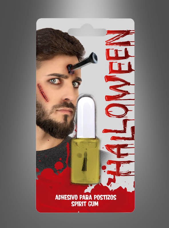 Verpackung mit der Abbildung eines Mannes mit künstlichen Halloween-Wunden und einem Nagel in der Stirn, darunter eine Flasche „Hautkleber 12 ml für Latexwunden“. Der Text lautet „HALLOWEEN“ und „Adhesivo para postizos Spirit Gum“. Dieser Mastix Hautkleber eignet sich ideal zum Befestigen von Latex-Prothesen oder zum Erzeugen realistischer Effekte mit Spirit Gum Latexkleber und ist perfekt für jede Kostümverwandlung.