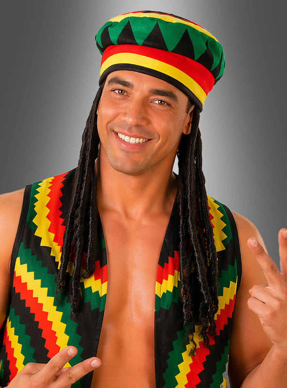 Ein lächelnder Mann trägt eine Jamaika-Rasta-Mütze und eine Weste mit schwarzen, gelben, roten und grünen Mustern und zeigt vor grauem Hintergrund zwei Peace-Zeichen, um die lebhafte Essenz der Reggae-Musik einzufangen.