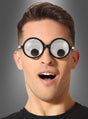 Ein Mann, der eine runde „Partybrille mit Wackelaugen“ trägt – eine lustige Brille mit großen, cartoonartigen, wackelnden Augen auf den Gläsern und einem vor Überraschung geöffneten Mund vor einem grauen Farbverlaufshintergrund – ein witziges Kostüm-Accessoire, das sich perfekt für jeden verspielten Anlass eignet.