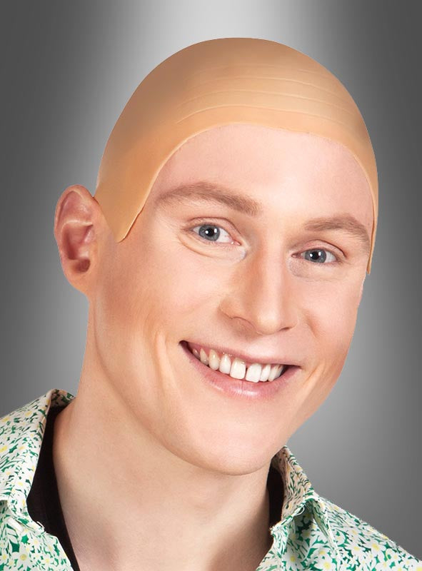 Eine lächelnde Person, die eine beige Latex-Glatzkopf-Perücke trägt – perfekt für den Karneval –, vor einem grauen Hintergrund mit Farbverlauf.
