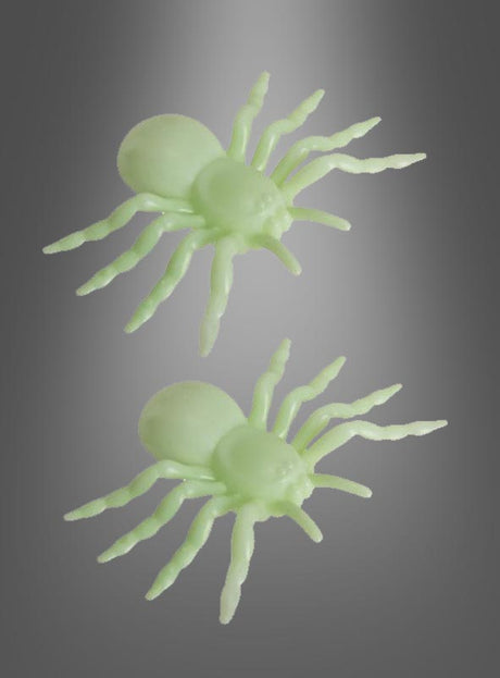 Zwei hellgrüne Plastikspinnen, die jeweils 10 cm groß sind, liegen auf einem grau abgestuften Hintergrund und sehen in Form und Größe identisch aus. Diese 2 Stück riesigen 10-cm-Leuchtspinnen von GID leuchten im Dunkeln und eignen sich daher perfekt als Halloween-Dekoration, um eine gruselige Atmosphäre zu schaffen.