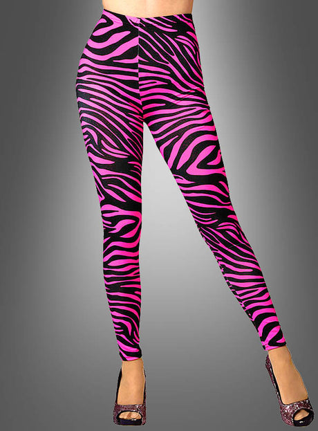 Eine Person in rosa Leggings mit Zebramuster und glitzernden High Heels, die vor einem grauen Hintergrund mit Farbverlauf steht – ein auffälliges Neonparty-Outfit, inspiriert vom Leggings-Stil der 80er Jahre.