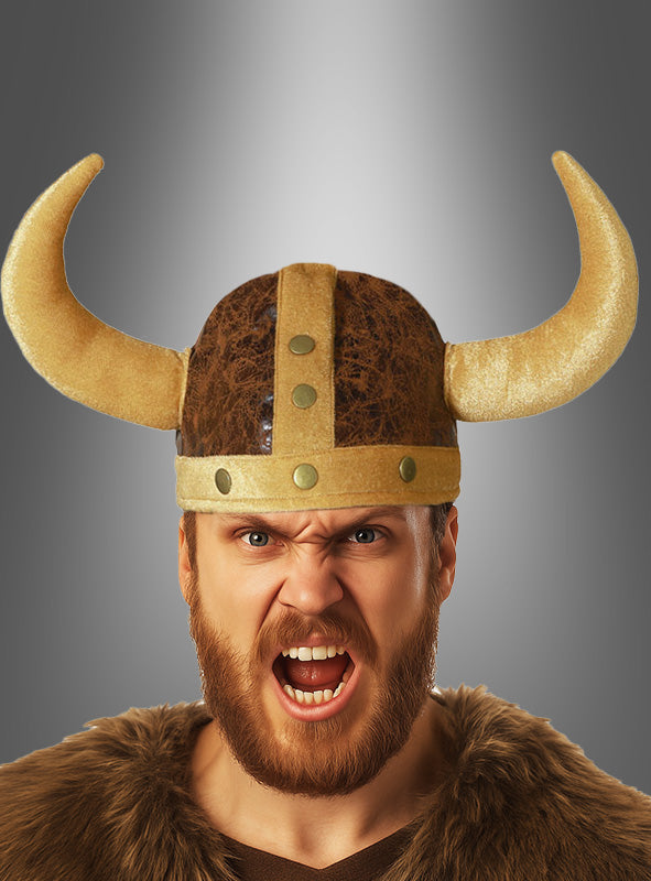 Eine bärtige Person trägt den „Wikinger Stoffhelm für Erwachsene“ – einen gehörnten Wikingerhelm aus Stoff – kombiniert mit Kunstfell, den Mund zum Schrei geöffnet, und steht vor einem schlichten Hintergrund mit Farbverlauf: das perfekte Kostüm-Accessoire für einen authentischen Wikinger-Look.