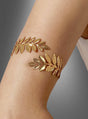 Die temporären Tattoos „Armschmuck Lorbeerkranz Metall gold“ sind auf der Seite eines Arms vor einem neutralen grauen Hintergrund abgebildet – damit sind sie der ideale goldene Armschmuck und das perfekte antike Kostüm-Accessoire für Ihre nächste Themenveranstaltung.