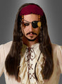 Eine Person in einem Piratenkostüm mit einem Rüschenhemd, einer langen braunen Piratenperücke mit Stirnband und Perlen, einer schwarzen Augenklappe und einem dunklen Bart vor einem grauen Hintergrund mit Farbverlauf.