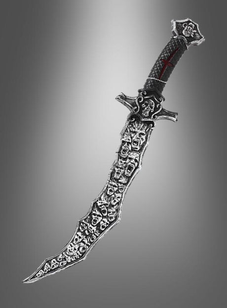 Gebogenes silbernes satanistisches Opferschwert mit Totenkopf, 56 cm, mit schwarzem Griff und zahlreichen Totenkopfmotiven entlang der Klinge vor einem grauen Hintergrund mit Farbverlauf – perfekt als Piratenmesser oder Halloween-Kostümzubehör, um deinen Look zu vervollständigen.