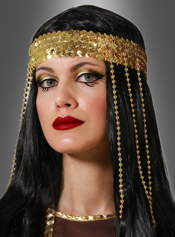 Eine Frau mit langen schwarzen Haaren trägt den „Goldener Pailletten Kopfschmuck“ mit Perlenketten, kräftigem schwarzem Eyeliner, goldenem Lidschatten und rotem Lippenstift vor grauem Hintergrund – ein auffälliges Karnevalskostüm-Accessoire, das sich ideal für orientalische Kostüme eignet.